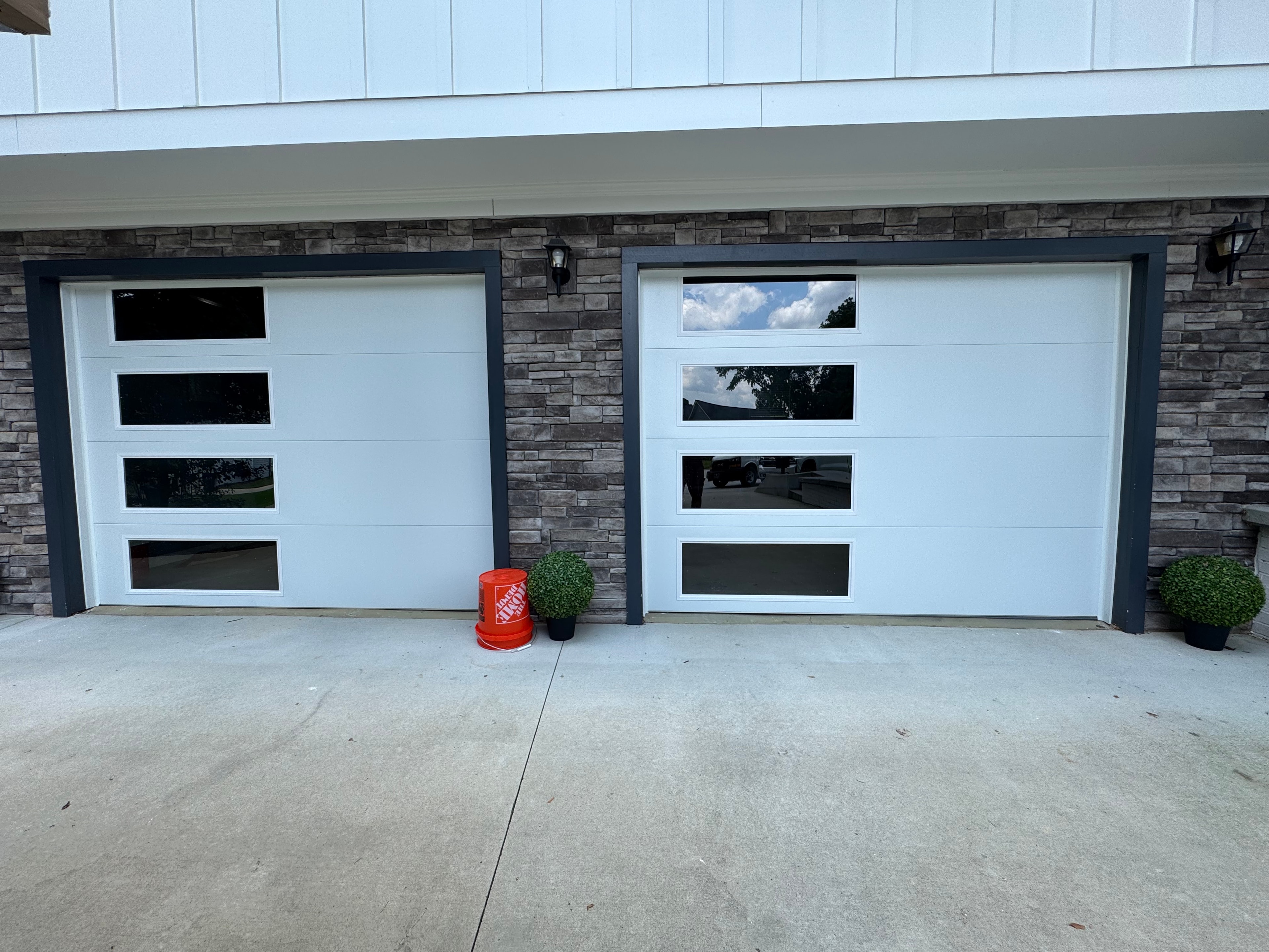 Modern white garage doors stone facade