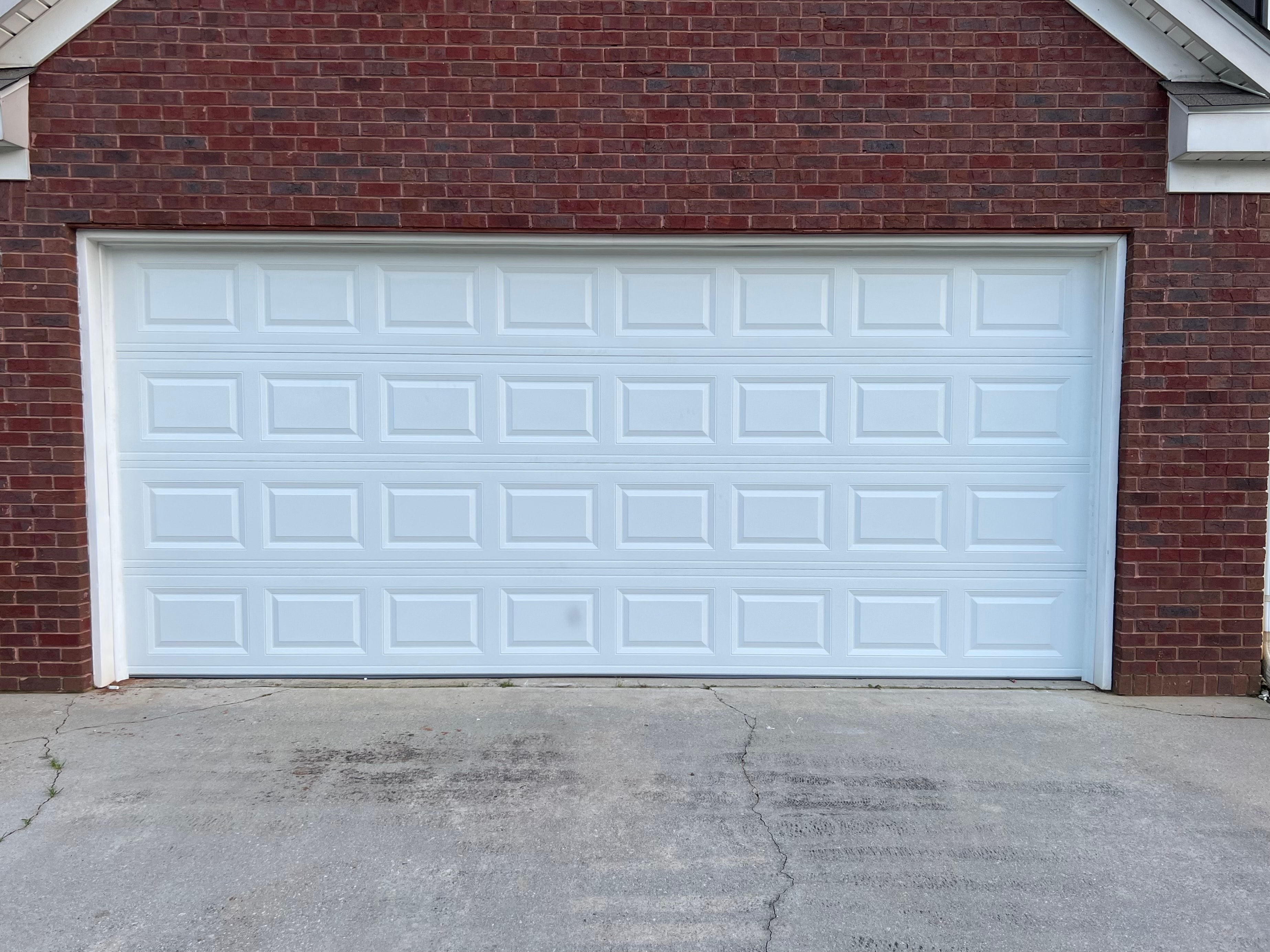 White garage door red brick house